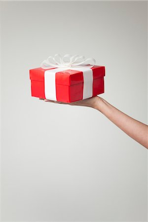 dar - Woman's arm holding out gift box, cropped Foto de stock - Sin royalties Premium, Código: 632-06029830