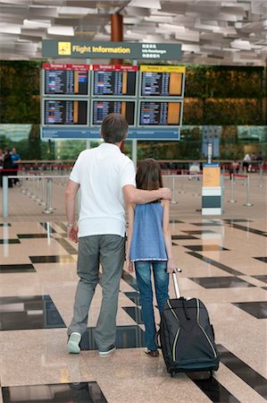 parent arm around shoulder mature - Father and daughter looking at arrival departure board in airport Stock Photo - Premium Royalty-Free, Code: 632-06029843