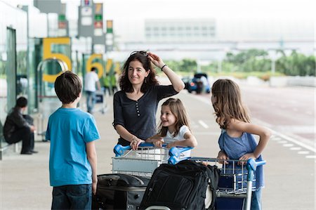 Family standing outside of airport with luggage Foto de stock - Sin royalties Premium, Código: 632-06029925