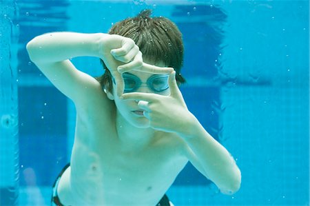short - Boy swimming underwater in swimming pool, hands forming finger frame Stock Photo - Premium Royalty-Free, Code: 632-06030014