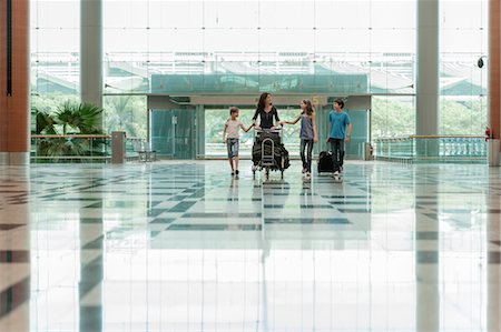 partir en voyage - Famille poussant des chariots de bagages dans le hall de l'aéroport Photographie de stock - Premium Libres de Droits, Code: 632-06030012