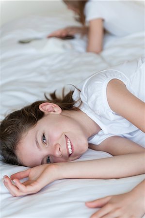 preteen girl joy - Girl lying on bed, smiling Stock Photo - Premium Royalty-Free, Code: 632-06030071