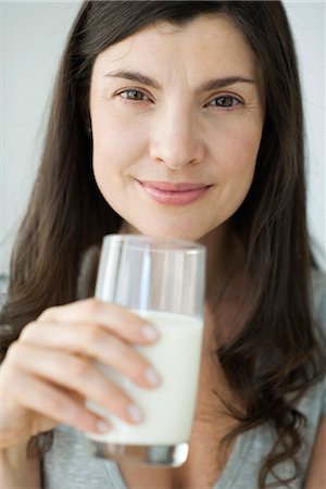 simsearch:632-08227404,k - Mid-adult woman holding glass of milk Stock Photo - Premium Royalty-Free, Code: 632-06030096