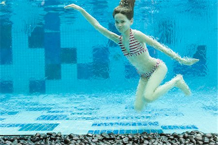 Girl swimming underwater in swimming pool Foto de stock - Sin royalties Premium, Código: 632-06030130