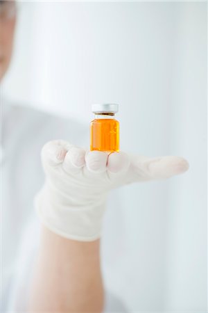 Scientist holding vial containing orange liquid Stock Photo - Premium Royalty-Free, Code: 632-06030153