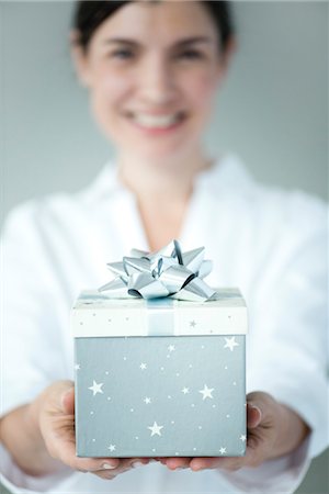 regalo de navidad - Woman holding gift box, focus on foreground Foto de stock - Sin royalties Premium, Código: 632-06030200