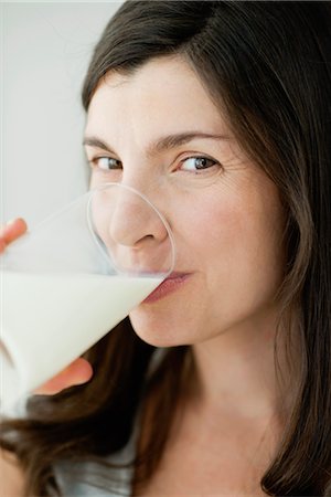 sideways glance - Mid-adult woman drinking glass of milk Stock Photo - Premium Royalty-Free, Code: 632-06030211