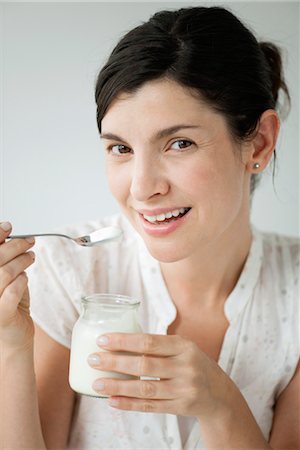 Mid-adult woman eating yogurt, portrait Foto de stock - Sin royalties Premium, Código: 632-06030212