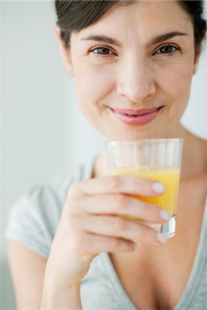 simsearch:632-08331609,k - Mid-adult woman with glass of orange juice Foto de stock - Sin royalties Premium, Código: 632-06030221