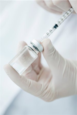 Extracting liquid from vial with syringe Stock Photo - Premium Royalty-Free, Code: 632-06030255