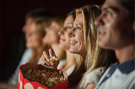 Woman eating popcorn while watching movie in theater Foto de stock - Sin royalties Premium, Código: 632-06118141