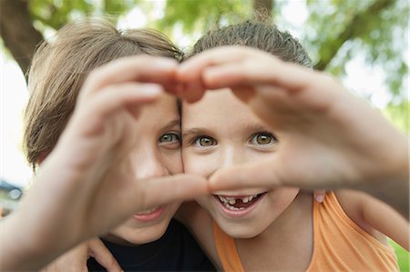 Boy and girl making heart shape with hands Foto de stock - Royalty Free Premium, Número: 632-06118201