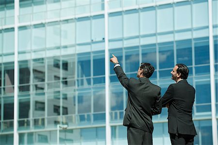 Business executives standing in front of office building, one pointing into distance Stock Photo - Premium Royalty-Free, Code: 632-06118214
