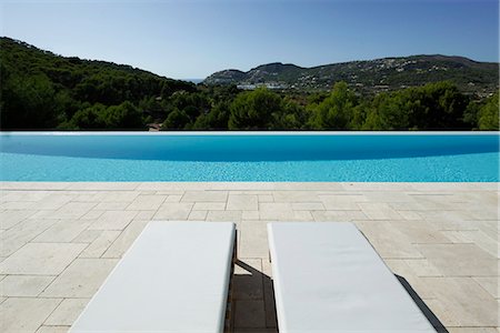 Lounge chairs beside swimming pool Foto de stock - Sin royalties Premium, Código: 632-06118261