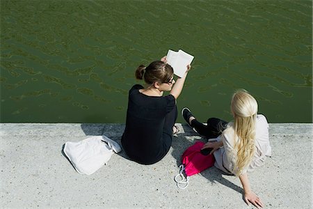 female friends sitting on ground - Young women relaxing together beside canal Stock Photo - Premium Royalty-Free, Code: 632-06118304