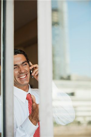 simsearch:632-06118255,k - Homme d'affaires à l'aide du téléphone portable au bureau, à partir de l'extérieur de la fenêtre Photographie de stock - Premium Libres de Droits, Code: 632-06118327