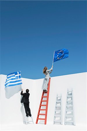 person climbing the ladder - Executives climbing ladders, holding European Union flag and Greek flag to symbolize economic crisis Stock Photo - Premium Royalty-Free, Code: 632-06118357