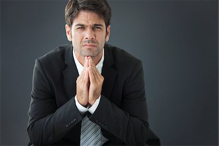 portrait concern adults only studio - Businessman with hands clasped under chin, disappointed expression on face Stock Photo - Premium Royalty-Free, Code: 632-06118650