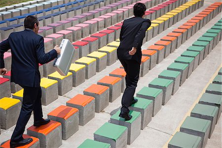 Business executives racing on bleachers, rear view Stock Photo - Premium Royalty-Free, Code: 632-06118679