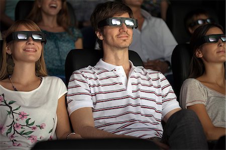 Audience enjoying 3-D movie in theater Foto de stock - Sin royalties Premium, Código: 632-06118680