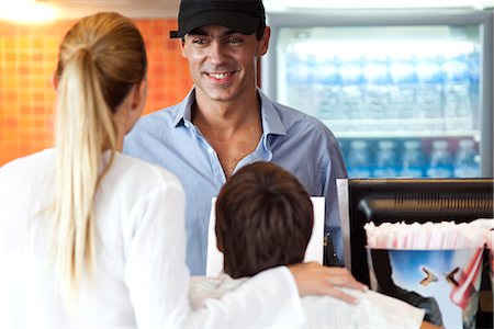 Man serving mother and son at snack counter Stock Photo - Premium Royalty-Free, Code: 632-06118760