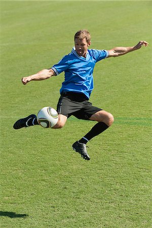 simsearch:632-06118662,k - Soccer player kicking ball in midair Stock Photo - Premium Royalty-Free, Code: 632-06118782