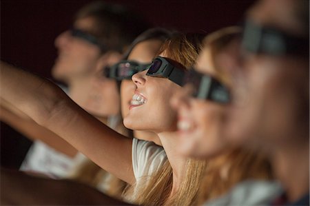 entertainment and movie - Woman wearing 3-D glasses in movie theater, arm reaching out Foto de stock - Sin royalties Premium, Código: 632-06118808