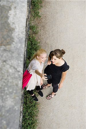 Young women posing for cell phone picture, high angle view Foto de stock - Sin royalties Premium, Código: 632-06118828