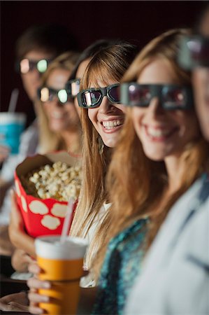 simsearch:632-03779499,k - Audience wearing 3-D glasses in movie theater, smiling at camera Foto de stock - Sin royalties Premium, Código: 632-06118846