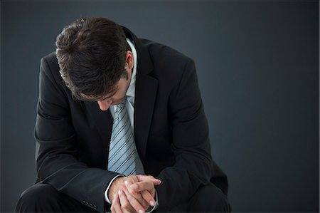 Businessman seated with head down in disappointment Stock Photo - Premium Royalty-Free, Code: 632-06118861