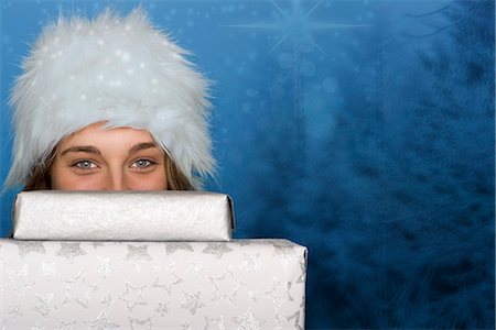 regalo de navidad - Young woman peeking over stack of Christmas gifts, portrait Foto de stock - Sin royalties Premium, Código: 632-06118891