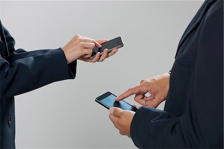 professional woman on phone - Colleagues exchanging information with smartphones, cropped Stock Photo - Premium Royalty-Free, Code: 632-06317063