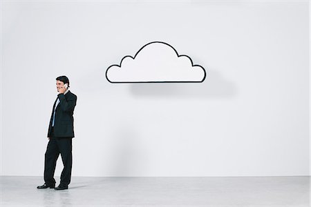 simsearch:632-06317362,k - Businessman talking on cell phone near graphic cloud representing cloud computing Stock Photo - Premium Royalty-Free, Code: 632-06317174