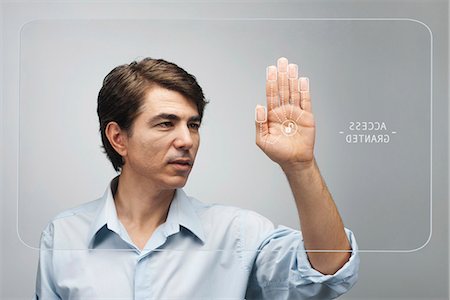 Man gaining access on touch screen interface using biometrics system Stock Photo - Premium Royalty-Free, Code: 632-06317190