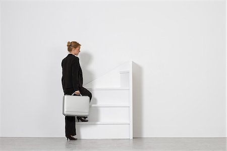 Businesswoman walking up incomplete staircase, rear view Foto de stock - Sin royalties Premium, Código: 632-06317240