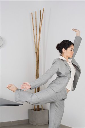 Young businesswoman doing yoga in office Stock Photo - Premium Royalty-Free, Code: 632-06317242