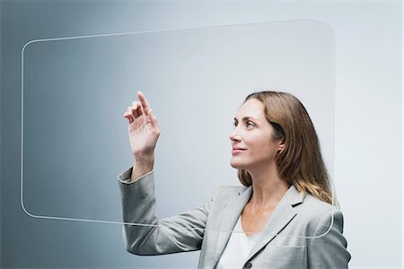 Businesswoman using large transparent touch screen Stock Photo - Premium Royalty-Free, Code: 632-06317289