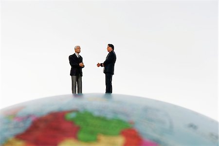 Businessman figurines standing on top of globe Stock Photo - Premium Royalty-Free, Code: 632-06317332