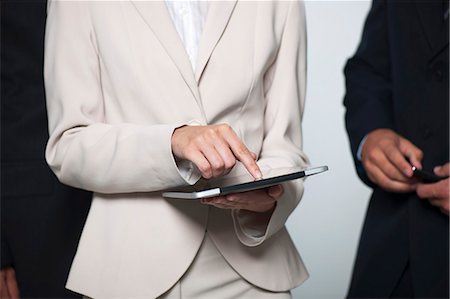 smart phone meeting - Businesswoman showing digital tablet to colleagues, cropped Stock Photo - Premium Royalty-Free, Code: 632-06317364