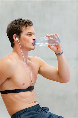 Barechested young man drinking bottled water Stock Photo - Premium Royalty-Free, Code: 632-06317365