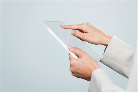 person holding hand as phone - Woman using transparent digital tablet, cropped Stock Photo - Premium Royalty-Free, Code: 632-06317383