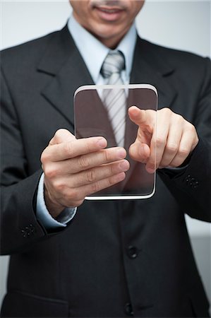 Businessman using transparent digital tablet Stock Photo - Premium Royalty-Free, Code: 632-06317398