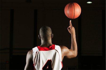 Basketball player spinning basketball atop finger, rear view Fotografie stock - Premium Royalty-Free, Codice: 632-06317563