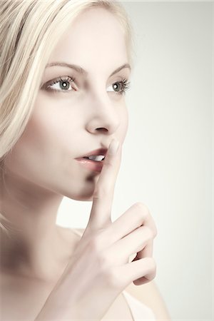 secret (mysterious or hidden) - Young woman with finger on lips Foto de stock - Sin royalties Premium, Código: 632-06317597