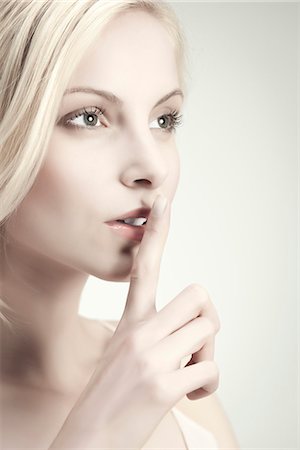 quiet and secret - Young woman with finger on lips Stock Photo - Premium Royalty-Free, Code: 632-06317597