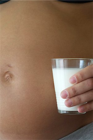 simsearch:632-06318000,k - Pregnant woman holding glass of milk beside stomach, cropped Fotografie stock - Premium Royalty-Free, Codice: 632-06317730