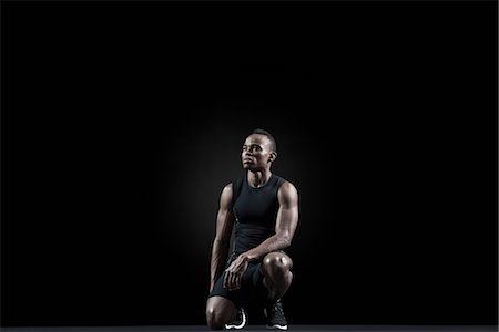 Athlete crouching, looking away in thought Foto de stock - Sin royalties Premium, Código: 632-06317985