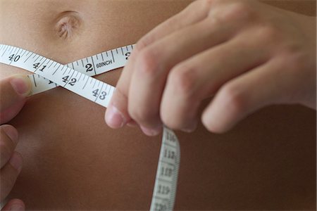 simsearch:632-06318000,k - Woman measuring stomach, cropped Fotografie stock - Premium Royalty-Free, Codice: 632-06318000