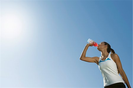 Female athlete drinking sports drink, low angle view Stock Photo - Premium Royalty-Free, Code: 632-06318061