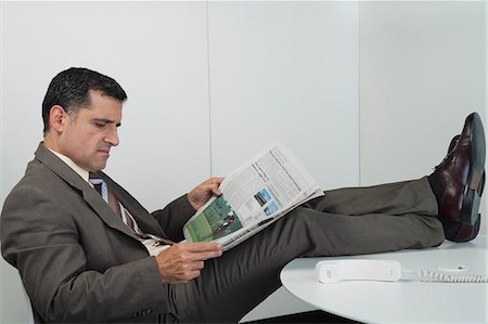 simsearch:632-01157392,k - Kaufmann lesen Zeitung im Büro mit Füßen auf Schreibtisch Stockbilder - Premium RF Lizenzfrei, Bildnummer: 632-06354024